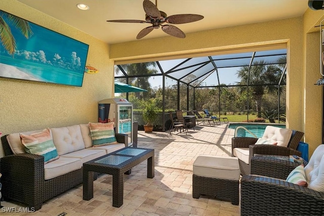 view of patio with outdoor lounge area, ceiling fan, a lanai, and a fenced in pool