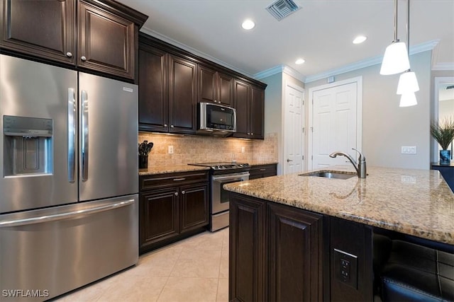 20256 Black Tree Ln, Estero, FL 33928 - kitchen with appliances with stainless steel finishes, ornamental molding, a sink, light stone counters, and backsplash