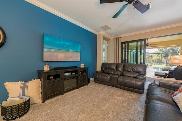 carpeted living room with ceiling fan and ornamental molding