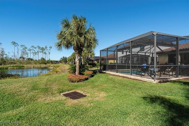 view of yard with a lanai, a patio area, and a water view