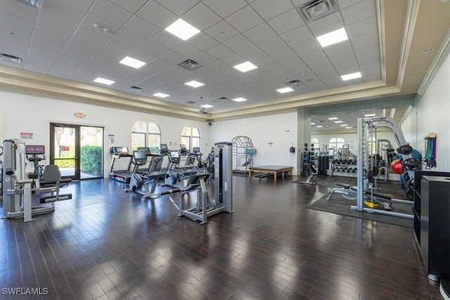 gym featuring dark wood-type flooring, a paneled ceiling, crown molding, and a raised ceiling