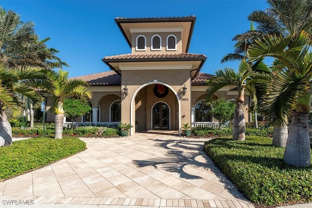 20256 Black Tree Ln, Estero, FL 33928 - view of front facade with stucco siding, a tiled roof, french doors, and a porch