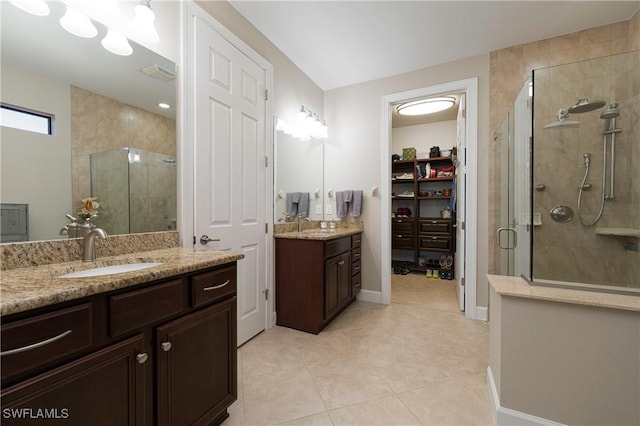 bathroom featuring tile patterned floors, vanity, and a shower with shower door