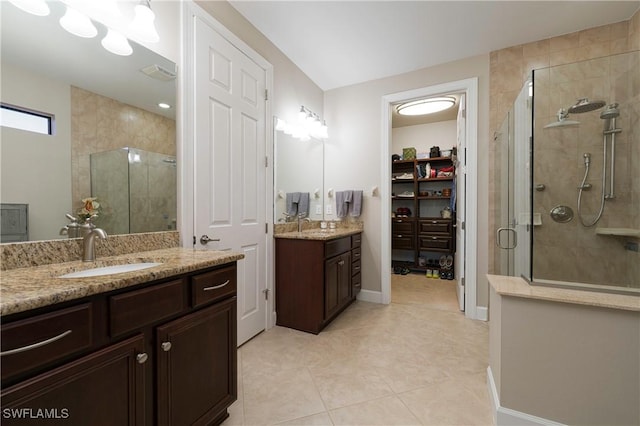 20256 Black Tree Ln, Estero, FL 33928 - full bath with a stall shower, tile patterned floors, a spacious closet, two vanities, and baseboards