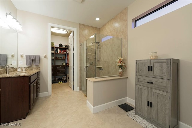 20256 Black Tree Ln, Estero, FL 33928 - bathroom featuring a stall shower, a spacious closet, vanity, tile patterned floors, and baseboards