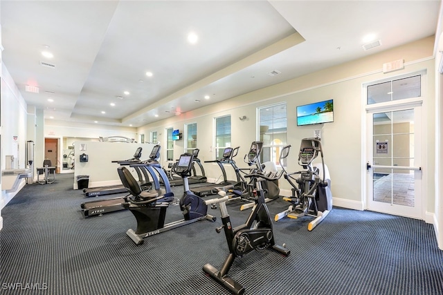 gym featuring a raised ceiling