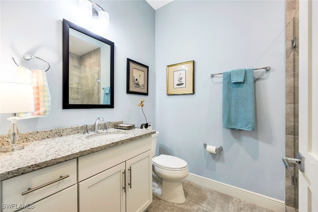 bathroom featuring tiled shower, vanity, and toilet