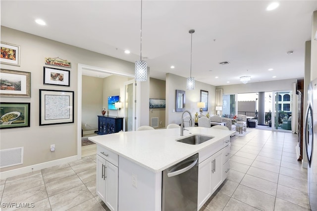 kitchen featuring sink, stainless steel dishwasher, an island with sink, decorative light fixtures, and white cabinetry