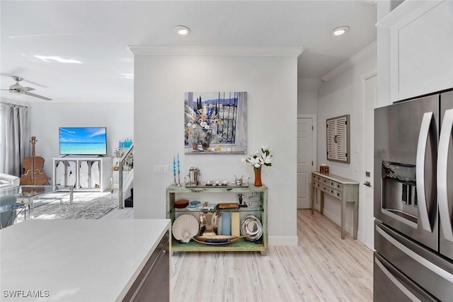 kitchen with white cabinetry, ceiling fan, stainless steel fridge with ice dispenser, light hardwood / wood-style flooring, and ornamental molding