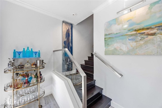 stairs featuring hardwood / wood-style floors and crown molding