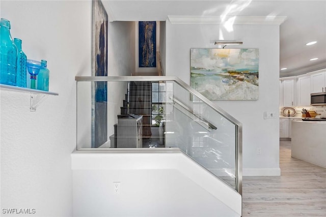 staircase featuring hardwood / wood-style flooring and ornamental molding