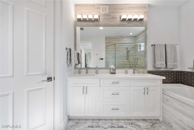 bathroom featuring vanity and separate shower and tub