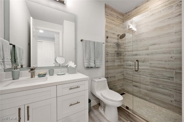 bathroom with vanity, toilet, wood-type flooring, and a shower with door