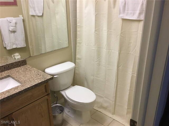 bathroom with tile patterned flooring, vanity, and toilet