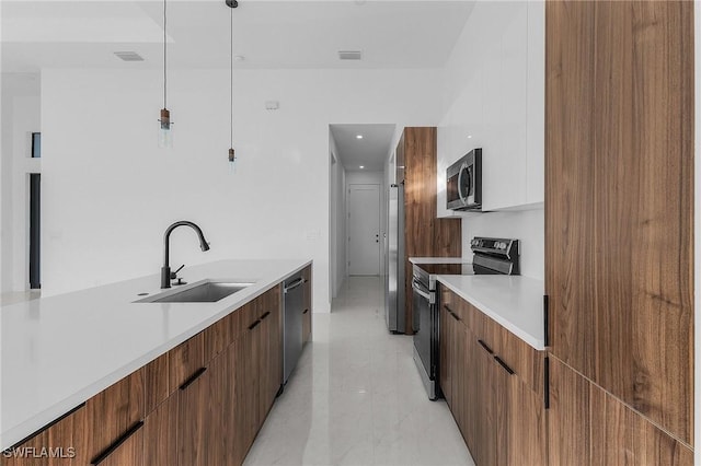 kitchen featuring sink, stainless steel appliances, and decorative light fixtures