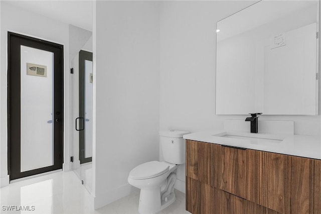 bathroom with toilet, vanity, and tile patterned floors