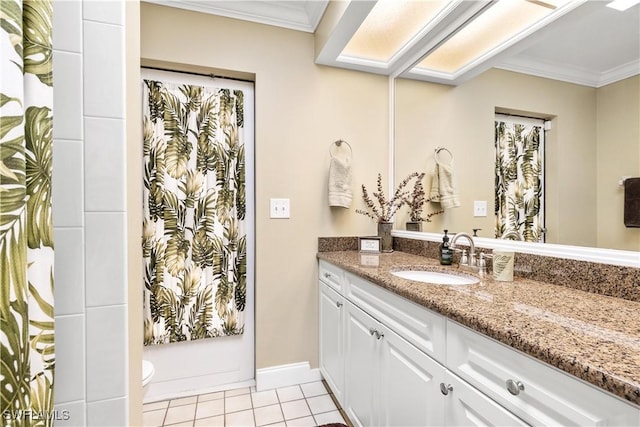 bathroom with tile patterned floors, crown molding, vanity, and toilet