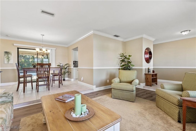 living room with crown molding, hardwood / wood-style floors, and an inviting chandelier