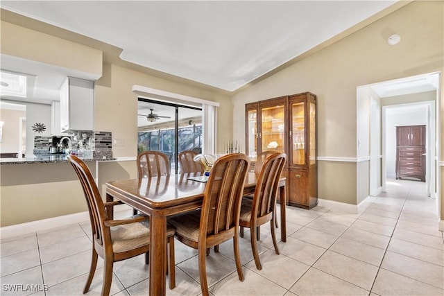 tiled dining room featuring sink and lofted ceiling