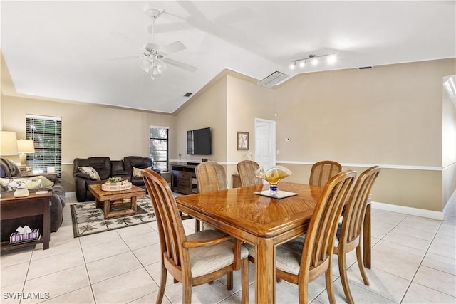 dining space with ceiling fan, light tile patterned floors, lofted ceiling, and rail lighting