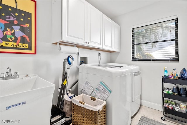 washroom featuring cabinets, separate washer and dryer, light tile patterned flooring, and sink