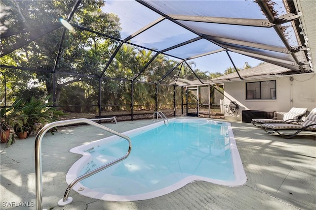 view of pool featuring glass enclosure and a patio area