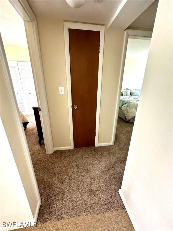 hallway featuring light colored carpet