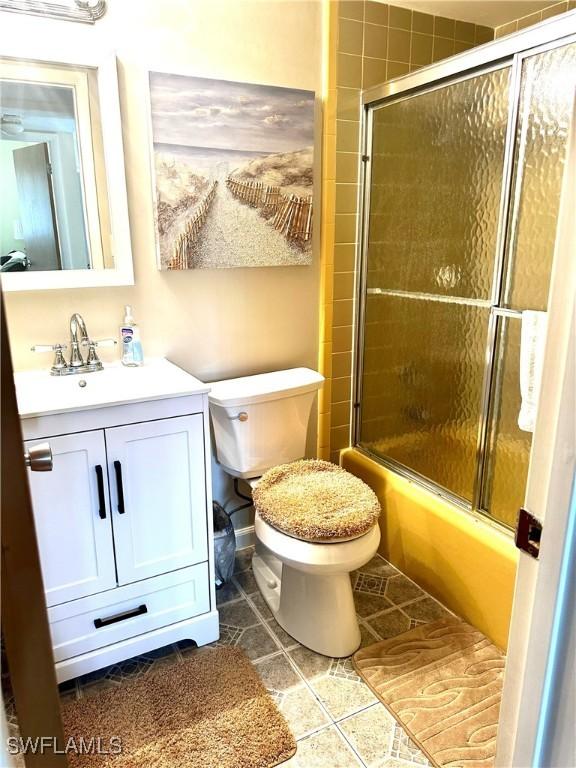 full bathroom with tile patterned flooring, toilet, combined bath / shower with glass door, and vanity