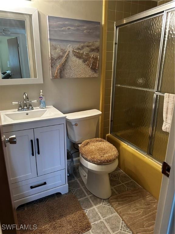 full bathroom featuring tile patterned floors, vanity, toilet, and shower / bath combination with glass door