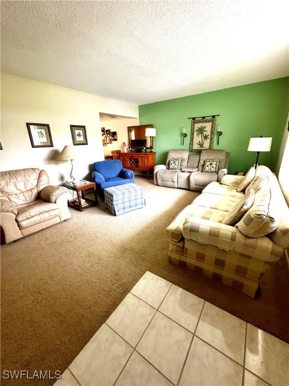 carpeted living room featuring a textured ceiling