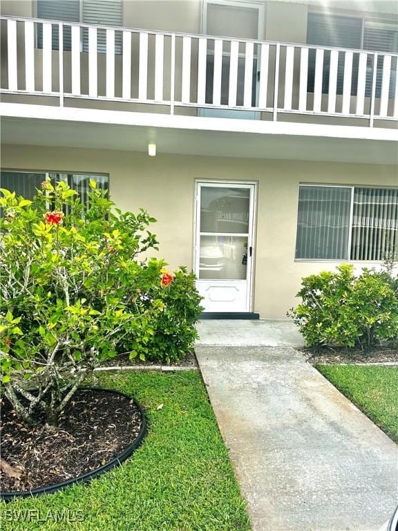 doorway to property with stucco siding and a balcony