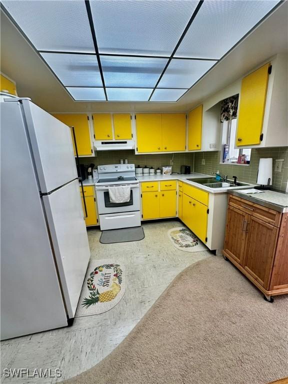 kitchen with decorative backsplash, white appliances, and sink