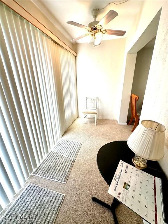 interior space featuring ceiling fan and light carpet