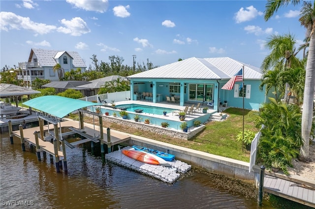 rear view of property with a yard, a water view, and a patio