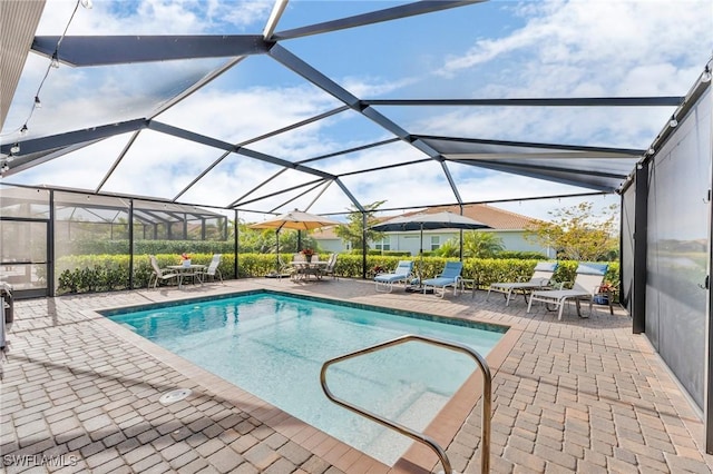 view of swimming pool with a patio area and a lanai