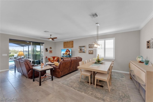 tiled dining area with ceiling fan and ornamental molding