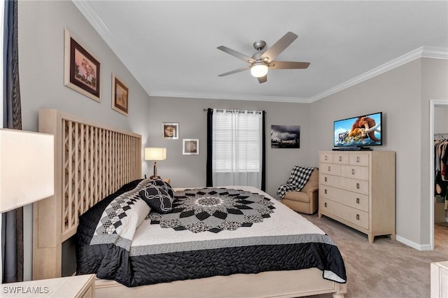 carpeted bedroom with ceiling fan, a closet, a spacious closet, and ornamental molding