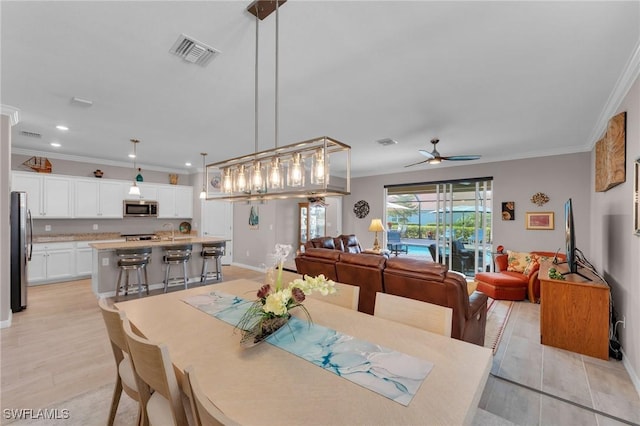 dining area featuring light hardwood / wood-style floors, ceiling fan, and crown molding