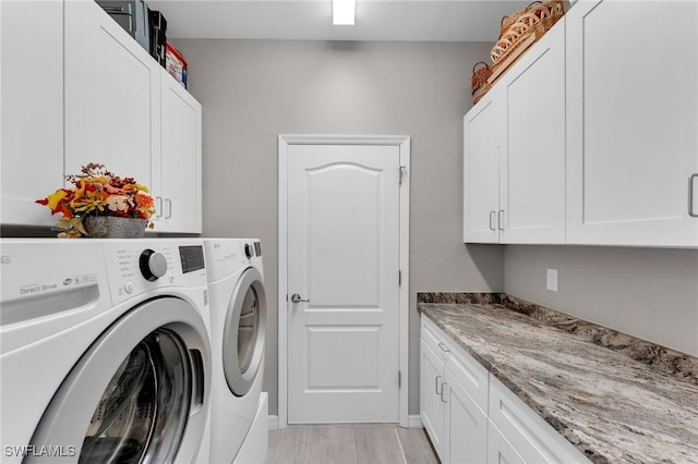 clothes washing area featuring light hardwood / wood-style flooring, cabinets, and independent washer and dryer