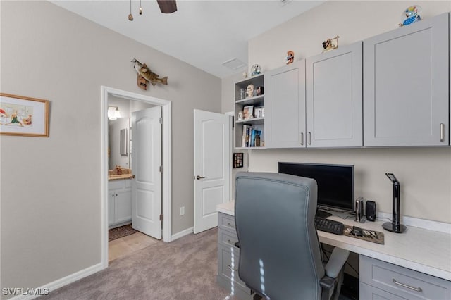 office space with light carpet, ceiling fan, and built in desk