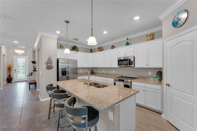 kitchen featuring stainless steel appliances, white cabinetry, a kitchen island with sink, and sink