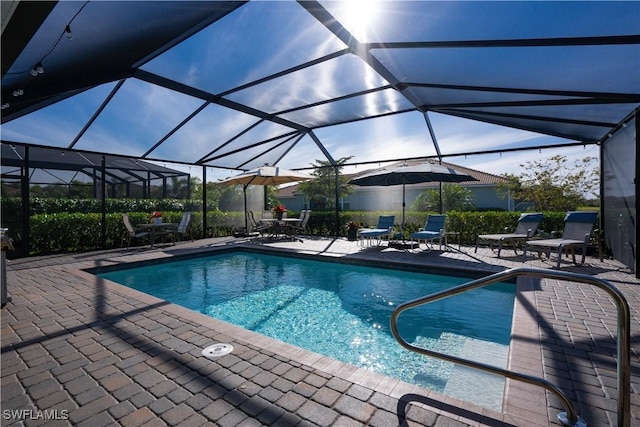 view of swimming pool featuring glass enclosure and a patio area