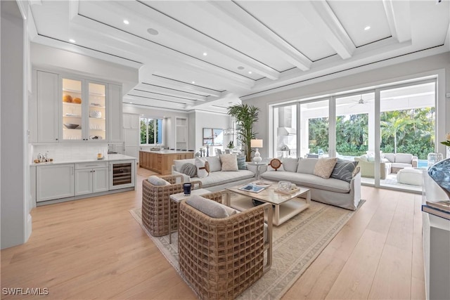 living room featuring beamed ceiling, beverage cooler, and light hardwood / wood-style floors