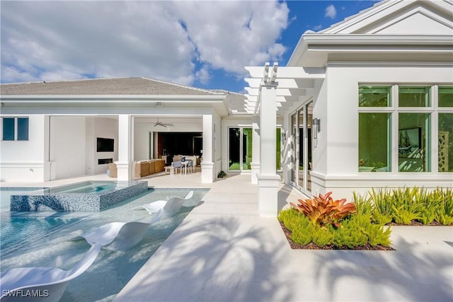 back of property with a swimming pool with hot tub, a pergola, a patio, and ceiling fan