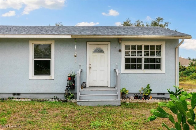 view of exterior entry with a yard