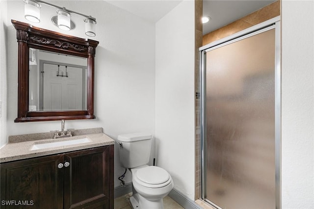 bathroom with tile patterned floors, vanity, toilet, and a shower with shower door