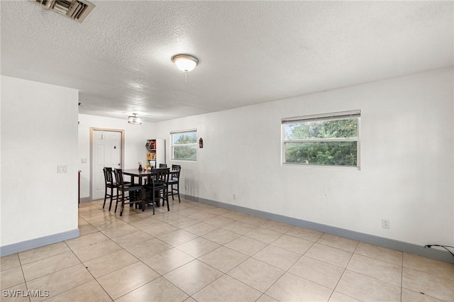 tiled dining room featuring a textured ceiling