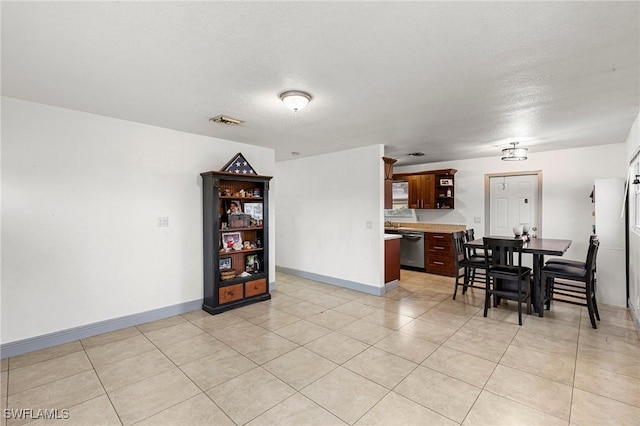 dining room featuring light tile patterned floors and a textured ceiling