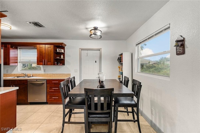 tiled dining area featuring sink and a textured ceiling