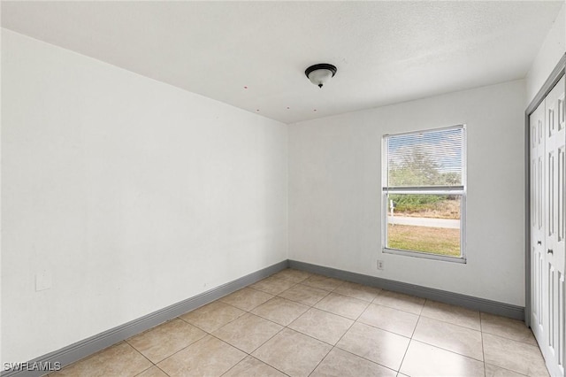 tiled spare room with a textured ceiling